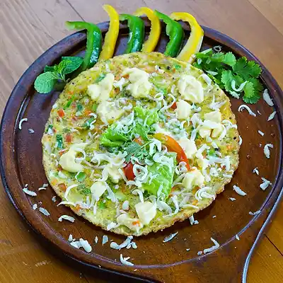 Omelette topped with cheese and herbs, served in a wooden skillet