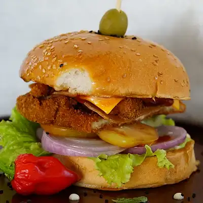 Crispy chicken burger with cheese, onion and lettuce in a sesame bun