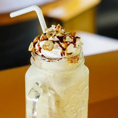 Iced milkshake topped with whipped cream and chocolate sauce