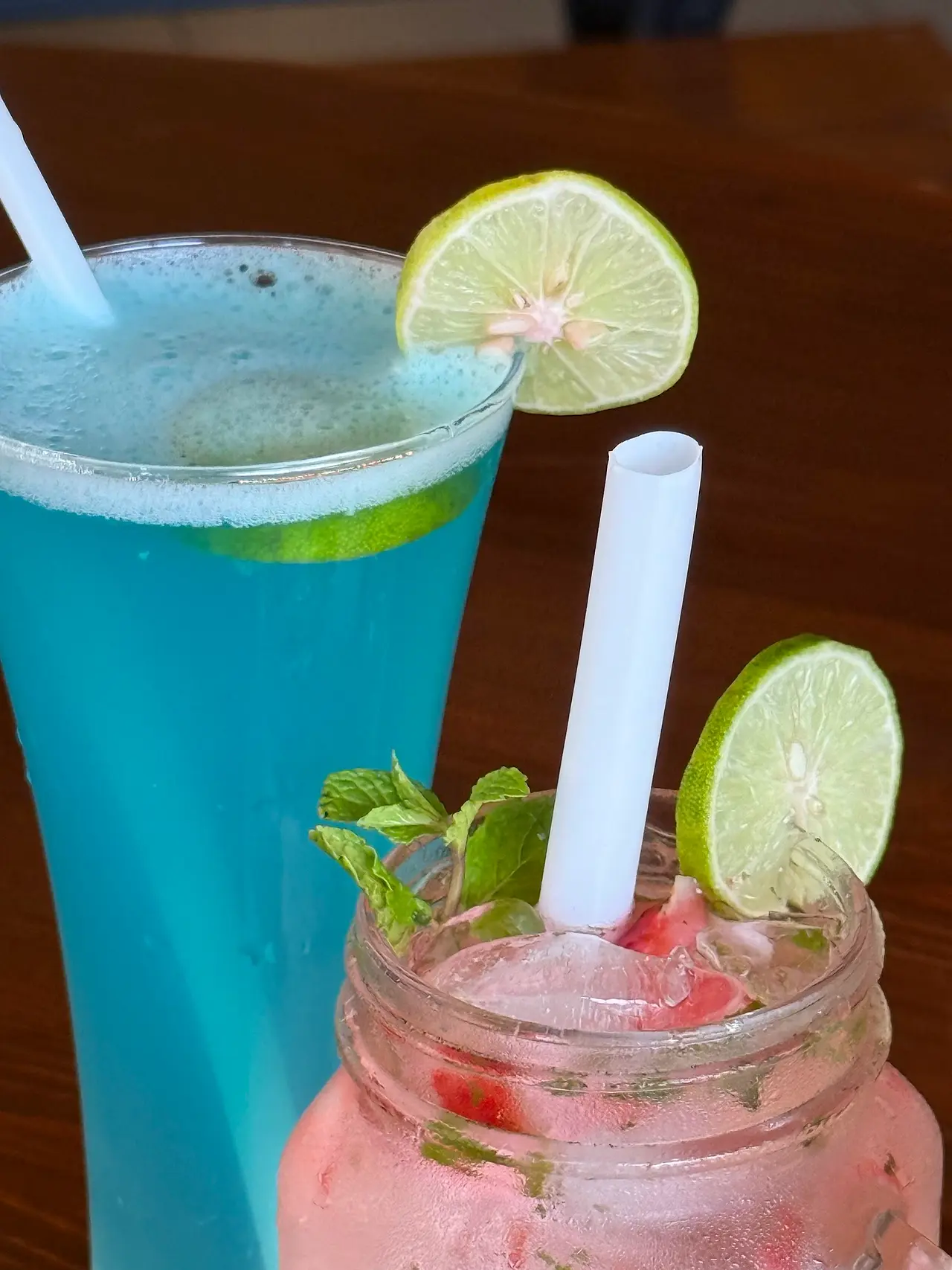 Blue lagoon style mocktail and a pink mojito with lime
