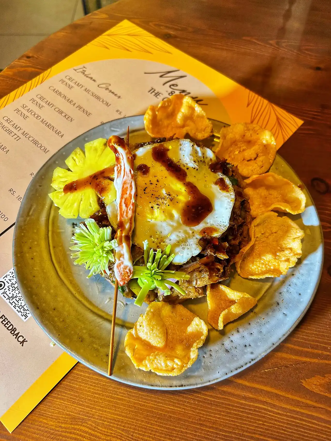 Chicken nasi goreng with a fried egg, prawn crackers and pineapple