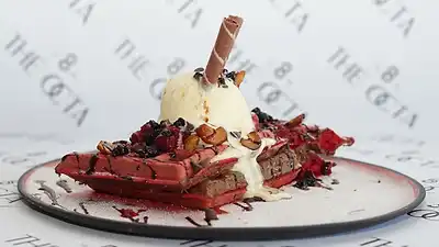 Waffle sandwich with ice cream and a chocolate stick