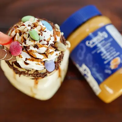 Peanut butter shake topped with cream and sweets