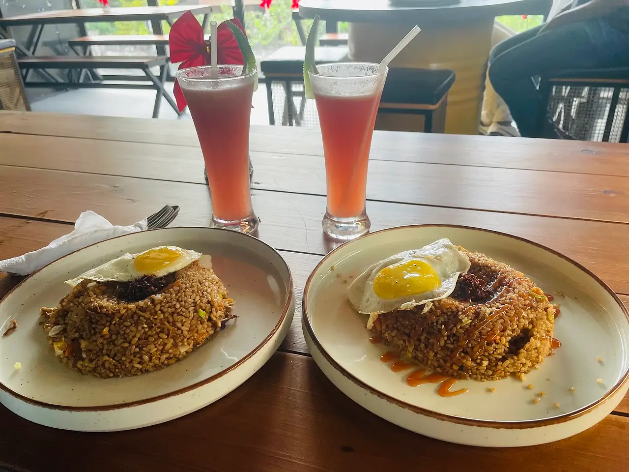 Two fresh juices and fried rice with fried eggs, photographed by a guest
