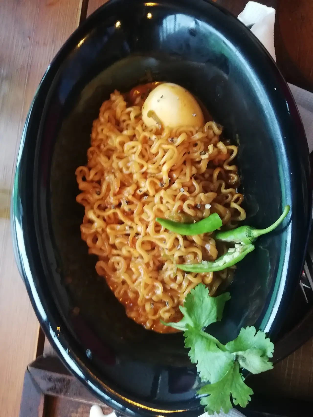 Spicy ramen with a boiled egg and green chilli, photographed by a guest