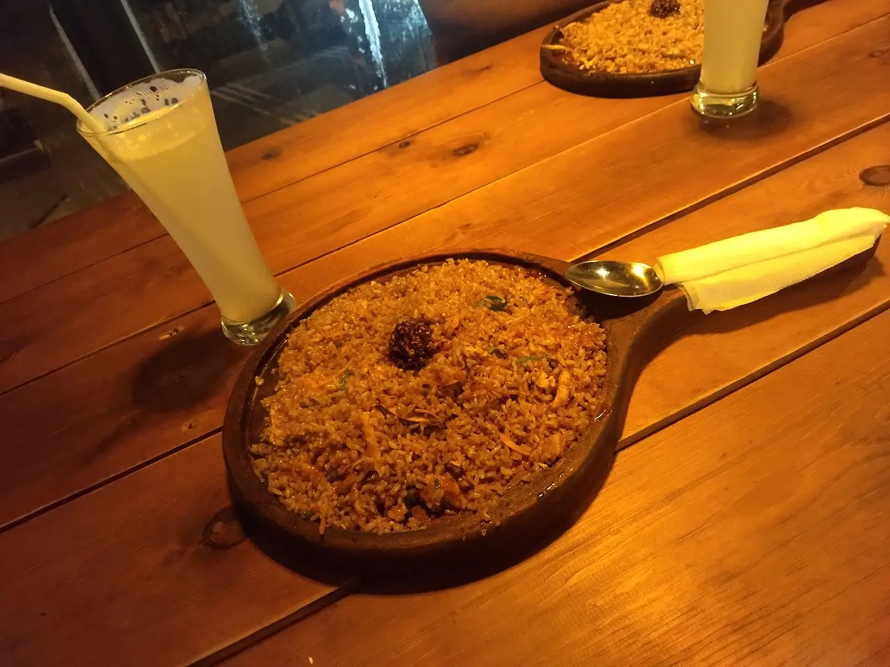Mongolian rice in a wooden skillet with a fresh juice, photographed by a guest