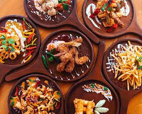 Seven wooden skillets of The Octa share plates: hot butter cuttlefish, crispy chicken, devilled bites and shoestring fries