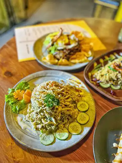 Fried noodles, nasi goreng and Mongolian rice shared on a table at The Octa